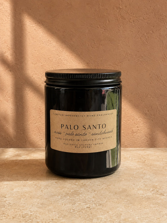 Palo Santo candle in a warm clay and stone setting